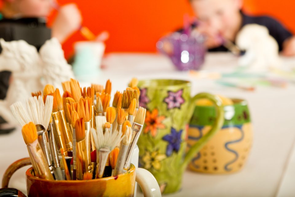 Hand painted pottery full of paintbrushes