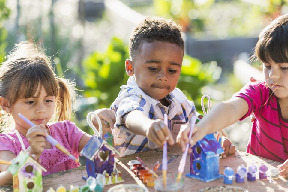 children painting bird houses at an art summer camp