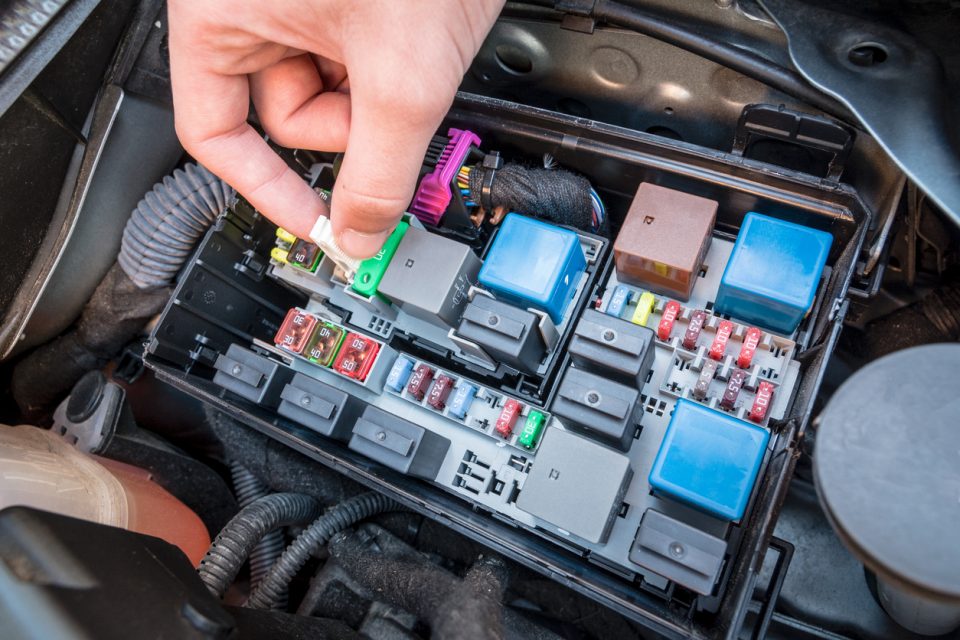 Hand showing how to check a blown fuse