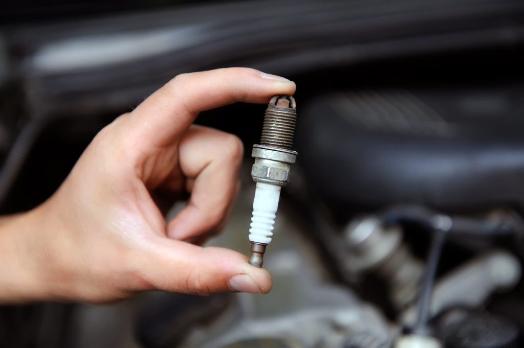 Auto mechanic holds a spark plug