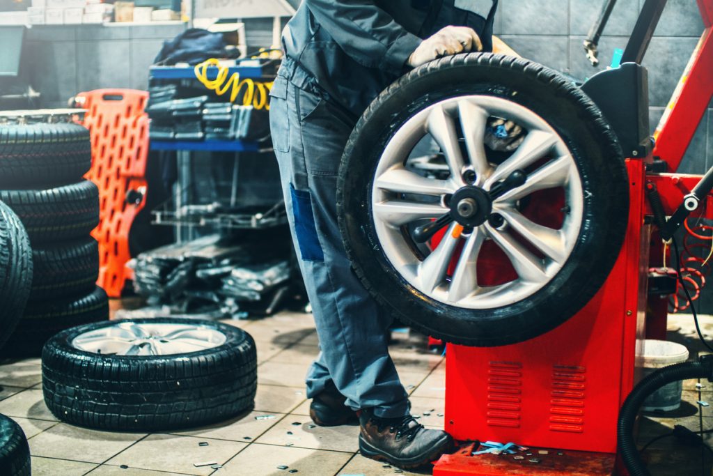 Auto mechanic performing work on tires
