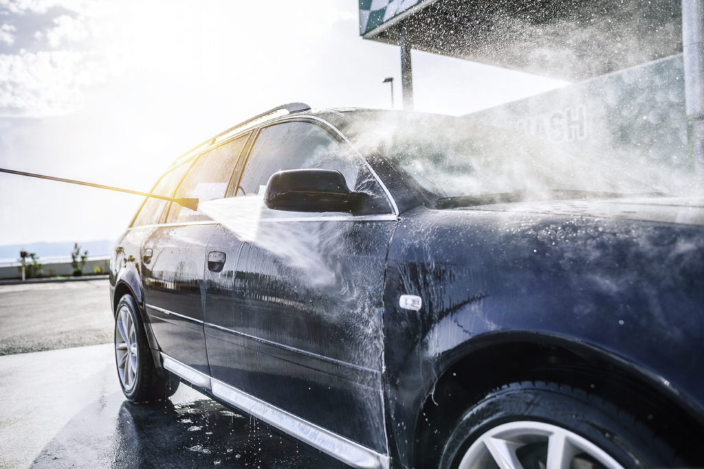 High-pressure washing car outdoors.