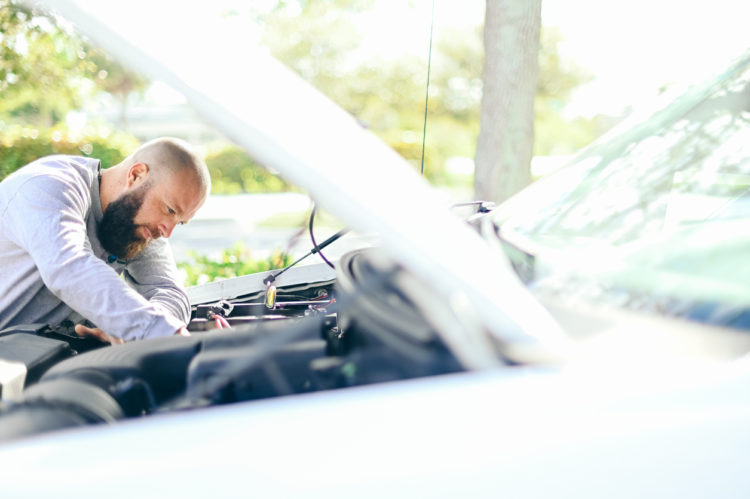 Man works under the hood of a car