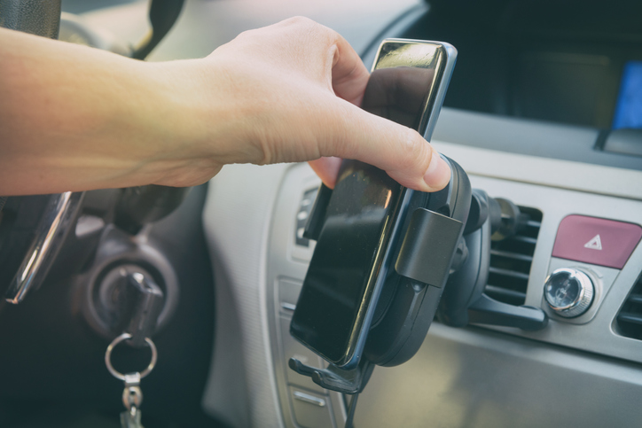 Modern wireless smartphone charging in a car. Dashboard in background.