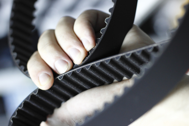 Mechanic is checking the timing belt of a modern car