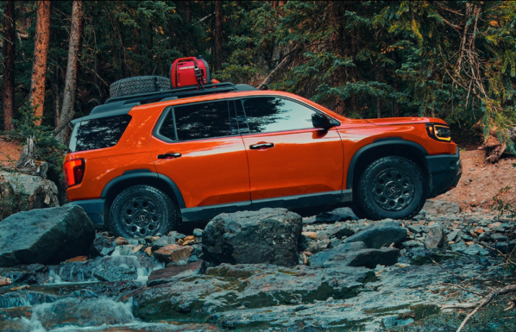 Honda: A Legacy of Excellence -- picture of an orange Passport traversing over a rocky riverbed