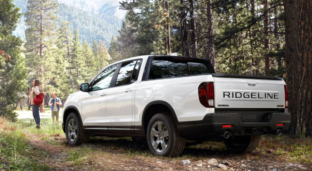 White Ridgeline parked in the woods with a couple standing near with hiking gear: Take A Look At The Ridgeline Trim Lineup