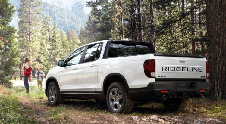 White Ridgeline parked in the woods with a couple standing near with hiking gear: Take A Look At The Ridgeline Trim Lineup